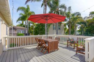 卡尔斯巴德Ultimate Beach Bungalow - 1 block from beach - huge backyard的甲板上配有一张带红伞的木桌