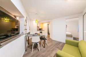 罗维尼Mariva Downtown apartment with free parking的厨房以及带桌椅的起居室。