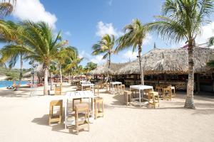 简蒂埃尔Villa Sol Paraiso的棕榈树海滩,海滩上摆放着桌椅