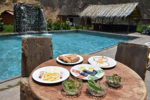 卡瓦纳科德Oasis Paraiso Ecolodge的游泳池旁带餐盘的桌子