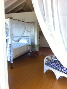 Five Islands VillageTreehouse Cottage的卧室配有白色的床,铺有木地板