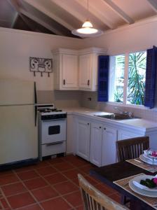 Five Islands VillageTreehouse Cottage的厨房配有白色橱柜和白色炉灶烤箱。