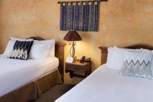 危地马拉老城酒店的酒店客房设有两张床和一张桌子上的台灯。