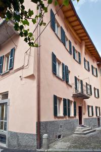 贝拉吉奥Locanda della Maria的粉红色的建筑,上面有绿色百叶窗