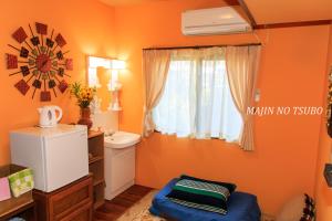 今归仁村精灵的罐子乡村民宿的一间拥有橙色墙壁和窗户的小浴室