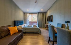 巴库里阿尼The Valley Bakuriani的一间带一张床和一张沙发的客厅和一间带一张床的房间