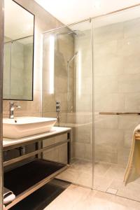 米里Amigo Hotel的一间带水槽和玻璃淋浴的浴室