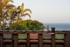 德班Hillside Guesthouse Umhlanga的阳台上摆放着一瓶葡萄酒,可俯瞰大海