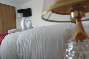 达赫拉Dakhla Sur Mer Hôtel的一张带白色床单和灯的床