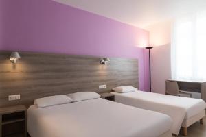 讷韦尔The Originals City, Hôtel Nevers Centre Gare (Inter-Hotel)的紫色墙壁客房的两张床