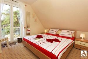 特拉森海德Strandstrasse 21 Fewo 06的一间卧室配有一张大床,上面有红色的弓