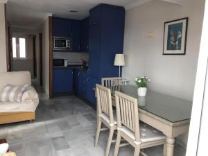 圣玛丽亚港Apartamento Playa La Muralla的厨房配有蓝色橱柜和桌椅