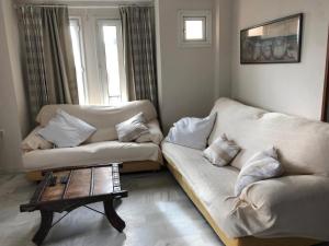 圣玛丽亚港Apartamento Playa La Muralla的客厅配有2张白色沙发和1张咖啡桌