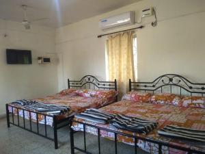 马尔冈Stay Goa的两张睡床彼此相邻,位于一个房间里