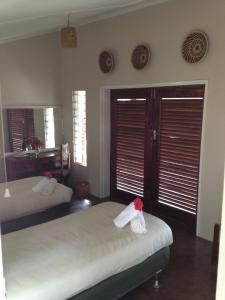ShanjunguMusungwa Safari Lodge的一间卧室设有两张床和两个百叶窗