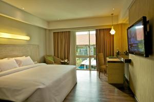 库塔库塔宾唐酒店的酒店客房设有一张大床和一台电视。