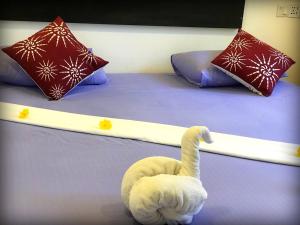 乌纳瓦图纳Monara Backpacker Inn Unawatuna的床上的白色天鹅,床上有枕头