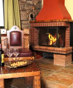 MariolátaMetohi的客厅设有壁炉和带酒杯的桌子