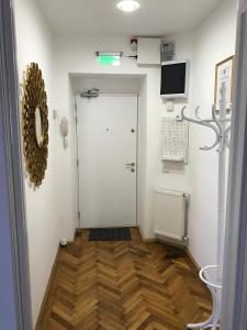 布加勒斯特VICTORIA LUXURY APARTMENT的走廊上设有白色门,铺有木地板