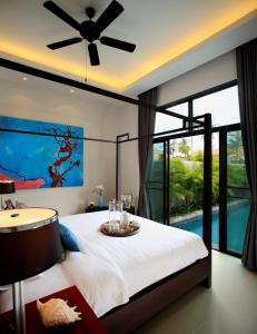 奈汉海滩Two Villas HOLIDAY - Onyx Style Nai Harn Beach, Phuket的一间卧室配有一张带吊扇的床