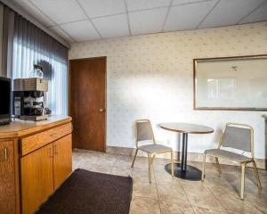 阿灵顿Rodeway Inn & Suites的一间设有桌子和两把椅子的房间和一间厨房