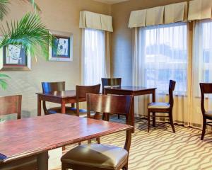 弗洛伦斯佛罗伦萨品质酒店的餐厅设有木桌、椅子和窗户。