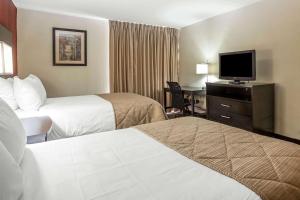 米尔堡Clarion Hotel Fort Mill Near Amusement Park的酒店客房设有两张床和一台平面电视。