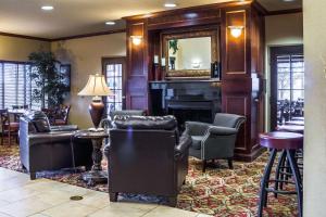 苏福尔斯苏福尔斯品质套房酒店的客厅设有壁炉、椅子和镜子