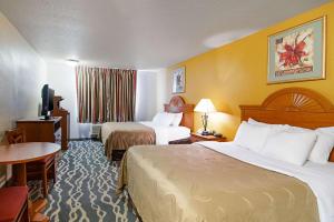 HuronQuality Inn Huron的酒店客房设有两张床和电视。