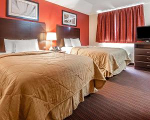 阿尔科阿尔科曼斯戴套房酒店的橙色墙壁的酒店客房内的两张床