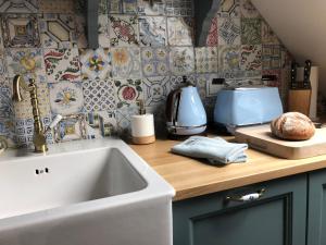 卡塞尔GRIMM'S LIVING的厨房设有水槽和瓷砖台面。