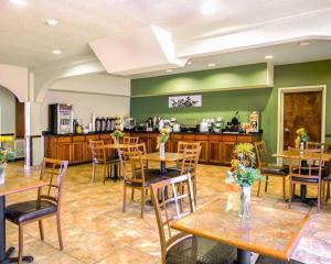 GonzalesSleep Inn & Suites near Palmetto State Park的一间带桌椅和柜台的餐厅