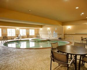 布达布达康福特套房酒店的一个带桌椅的大型室内游泳池