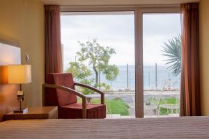 奥埃拉斯奥埃拉什因娜酒店的酒店的客房 - 带一张床、椅子和窗户