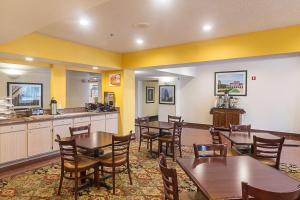 休斯顿Quality Inn & Suites West Chase的一间带桌椅的餐厅和一间厨房