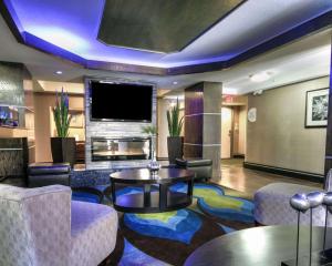 埃尔帕索舒适旅馆及套房I-10机场酒店的酒店大堂配有电视和桌椅