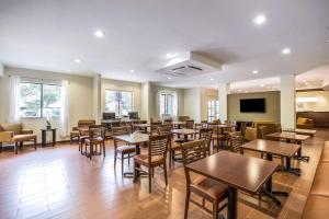 达拉斯达拉斯爱田医疗区司丽普酒店的餐厅设有桌椅和平面电视。