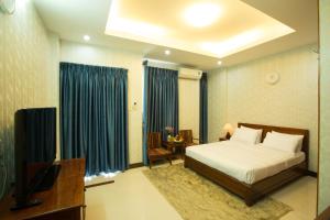 胡志明市Ben Thanh Retreats Hotel的一间卧室配有一张床和一台电视