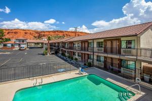 圣乔治Rodeway Inn St George North - Near Pioneer Park的一座带停车场的大楼前的游泳池