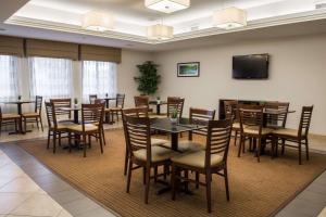 Brandermill米德罗港口司丽普套房酒店的用餐室配有桌椅和平面电视。