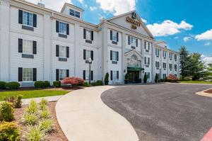 哈里森堡Quality Inn Harrisonburg I-81的前面有一条街道的白色建筑