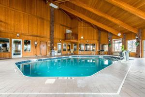 Weirton韦尔顿康福特茵酒店的一座大型游泳池,位于一座拥有木制天花板的建筑中