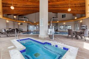 拉勒米Comfort Inn & Suites Near University of Wyoming的一座带桌椅的游泳池