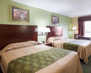 新奥尔良Rodeway Inn & Suites的绿墙旅馆客房的两张床