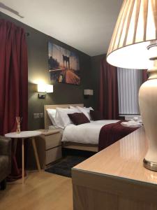 考文垂Bede Apartments的酒店客房设有一张大床和一张桌子。