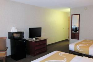 阿尔伯克基Quality Inn & Suites Albuquerque Downtown University的酒店客房带两张床、一台电视机和一间卧室