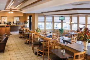 阿尔伯克基Quality Inn & Suites Albuquerque Downtown University的餐厅设有桌椅和窗户。