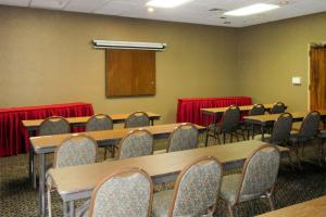 阿尔伯克基Quality Inn & Suites Albuquerque Downtown University的配有桌椅和讲台的会议室