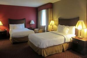 OwegoQuality Inn & Suites Owego的酒店客房,配有两张床和椅子