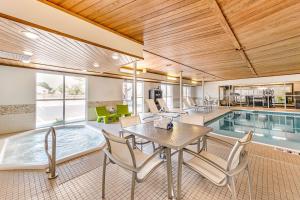 柯林斯堡Quality Inn & Suites University Fort Collins的一座带游泳池和桌椅的房子